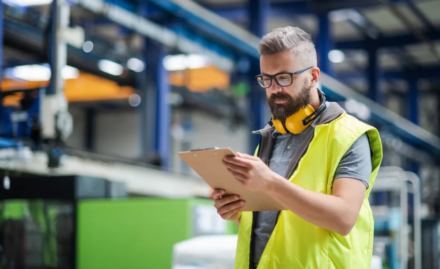 Technician reviewing operating information on a factory floor